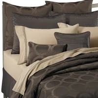 A dark brown duvet with a circle pattern in it.