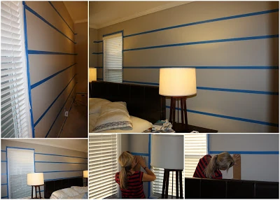 Blue painters tape on the wall before painting the stripes.