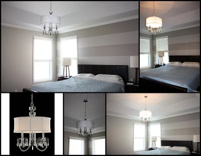 The master bedroom with a chandelier light with a shade.
