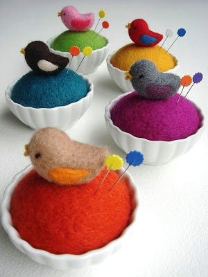 Pincushions in orange, purple and yellow.