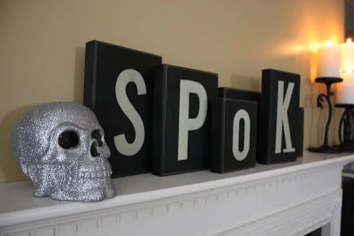 A glittery skull beside the word spooky on the mantel.
