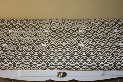 The patterned brown and white coffee table fabric top.