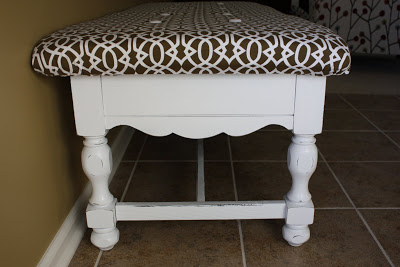 The side view of the white coffee table with the brown and white cushion.