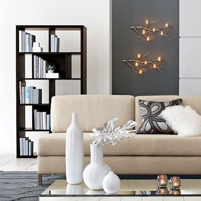 A neutral living room with branch candle holders above the couch.