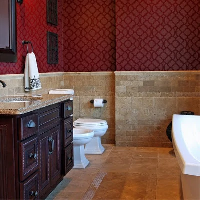 A deep red and Burgundy stencilled wall in a bathroom.