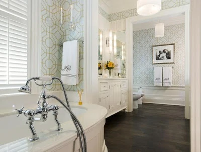 A mostly white bathroom with wooden floors and a geometric design on the walls.