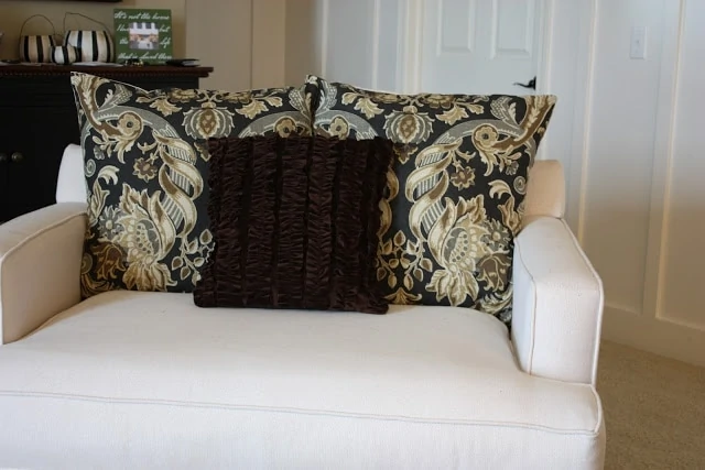 Armchair with velvet pillow on it.