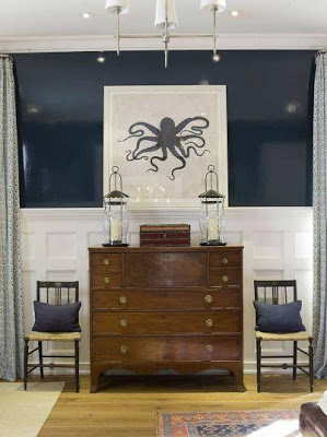A wooden dresser with an octopus drawing above it.