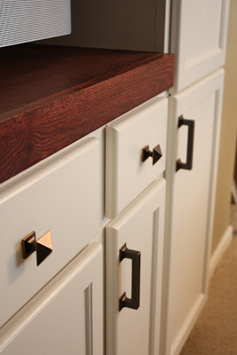 The brass pulls on the cabinets.