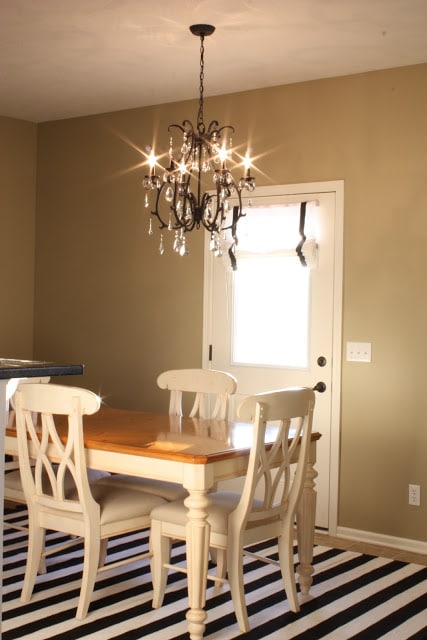 Pottery Barn Celeste Chandelier in a dining room with a black and white striped rug