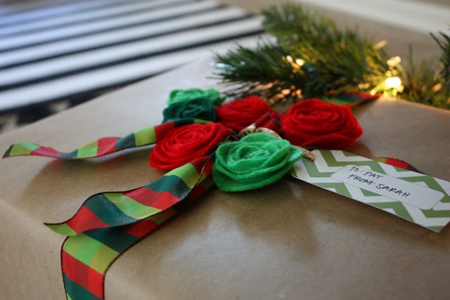A present all wrapped up with pretty rosette flowers on top.