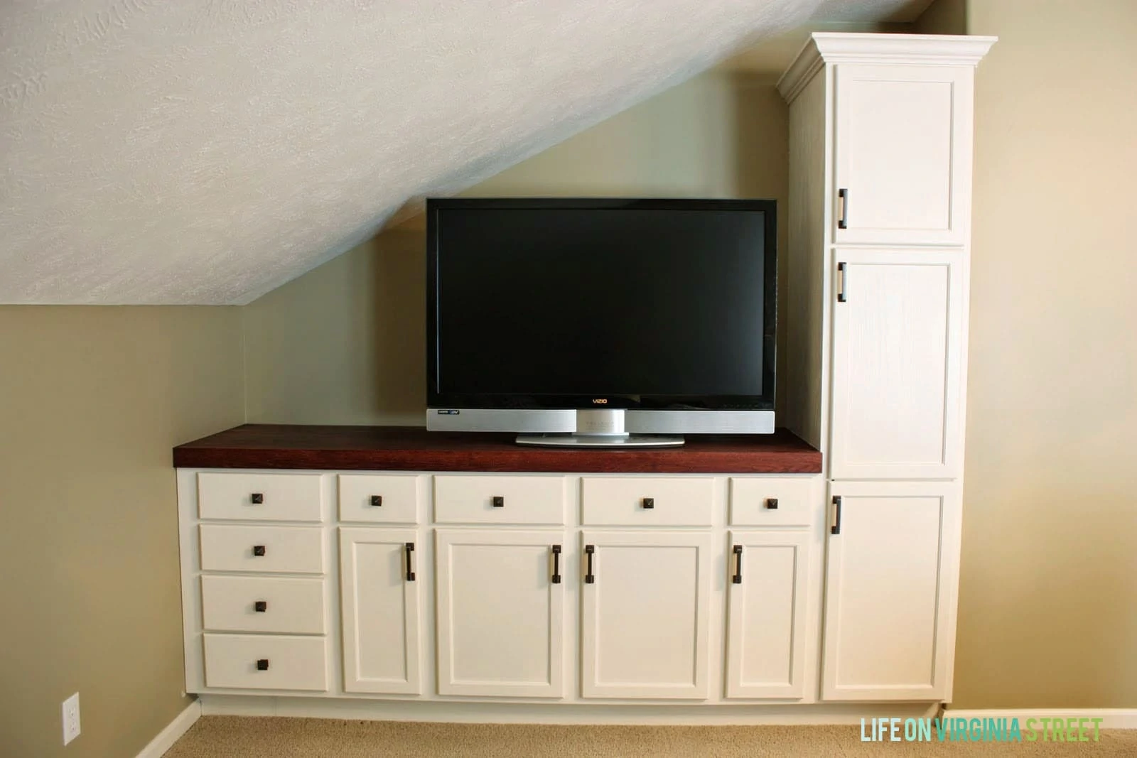 DIY entertainment center with kitchen cabinets painted white.