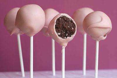 Pink cake pops with a bite taken out of one.