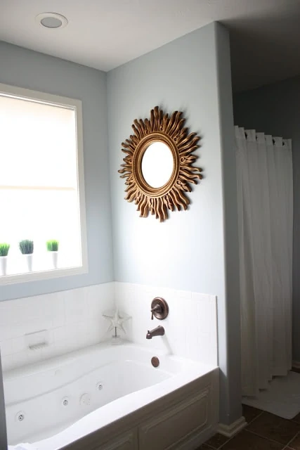 The golden mirror in bathroom above the tub.