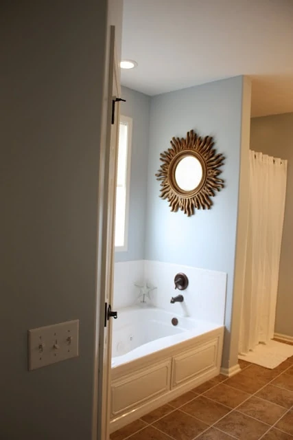 A full look into the bathroom with the golden mirror being the focal piece.