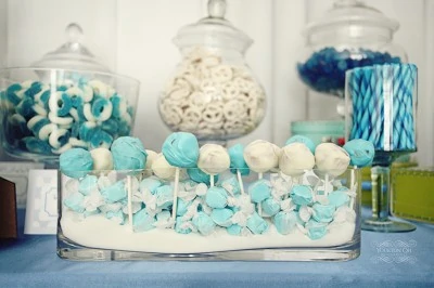 Blue and white cake pops on a dessert table.