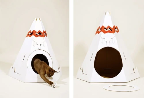 A white and orange teepee with a cat inside it.