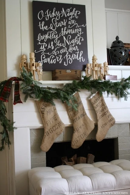 The O Holy Night Print hanging above the fireplace with stockings on the fireplace too.
