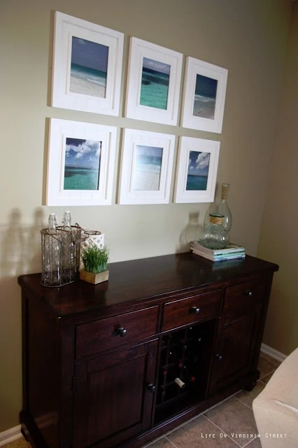 Dining room buffet table with beach art gallery wall.