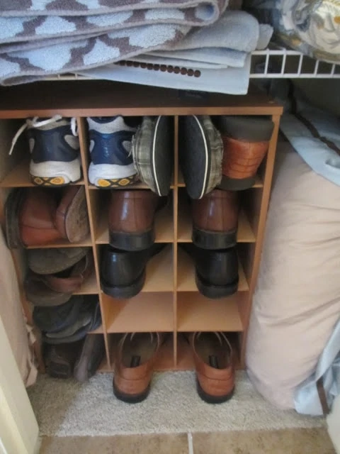 A cubby hole filled with men's shoes.