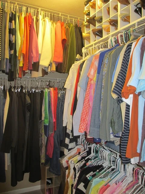 Rows of clothes in the closet all hung up and in order.