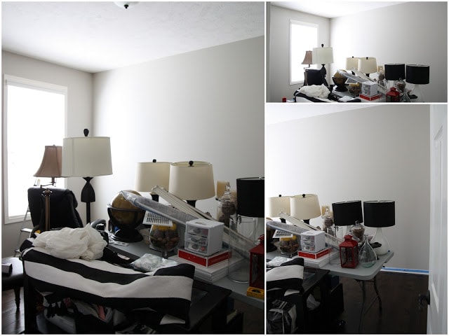 The room painted white with all the stuff in the middle of the room piled up.