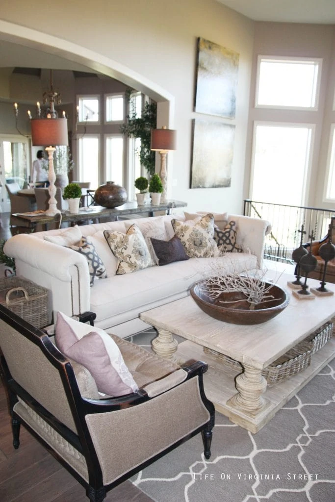 Gorgeous French-style living room with driftwood pillar coffee table, linen chesterfield sofa, gray and tan accents.