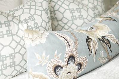 Soft blue and white floral pillows on the bed.