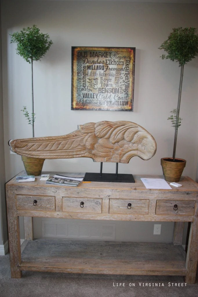Carved wood angel wing on the side table.