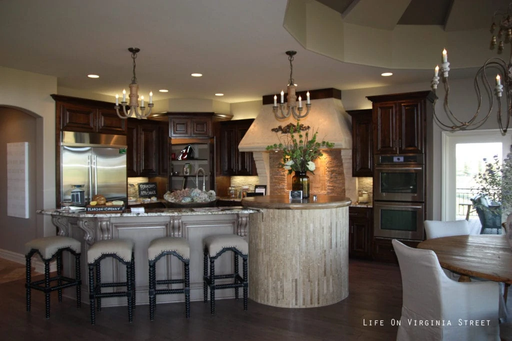 Large kitchen with an island and barstools around it.