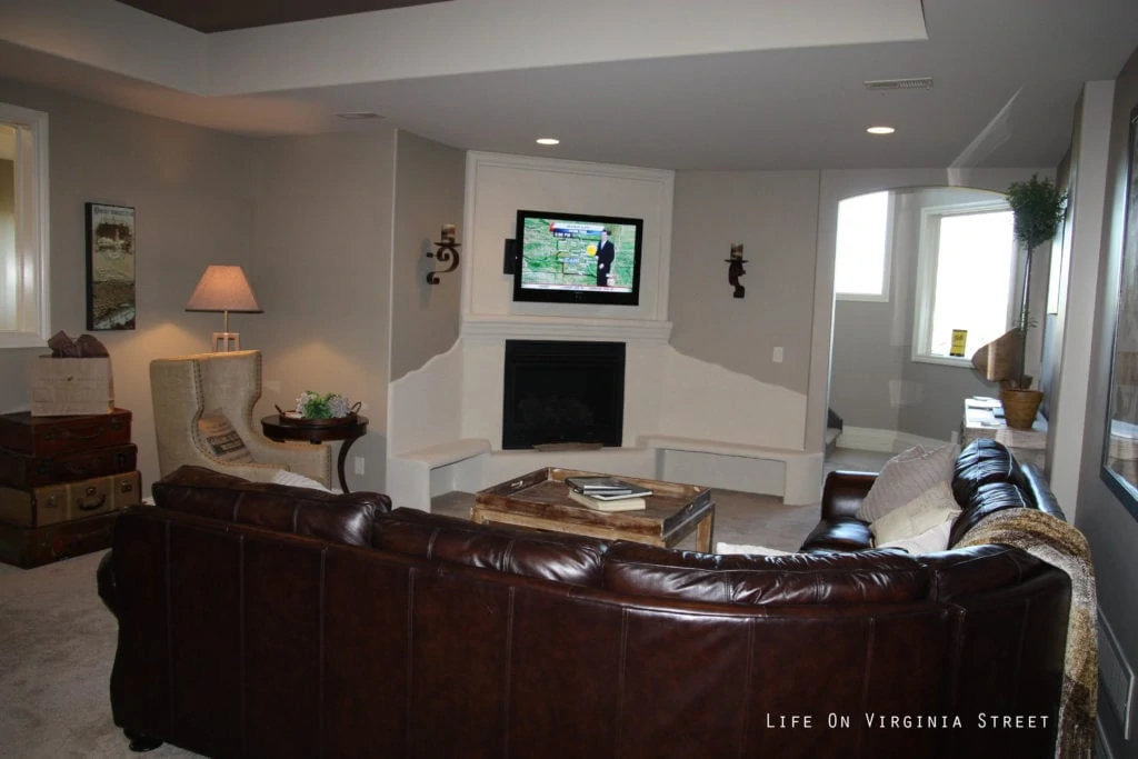 The recreation room with a TV hanging above the fireplace.