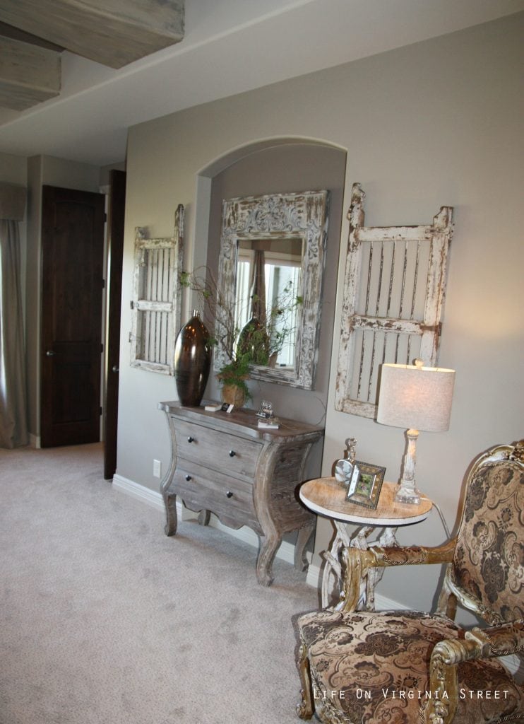 Master bedroom nook with wood furniture and old shutters on the wall.