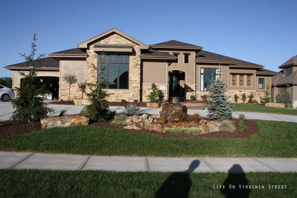 The outside of the house with tan colored stone siding.