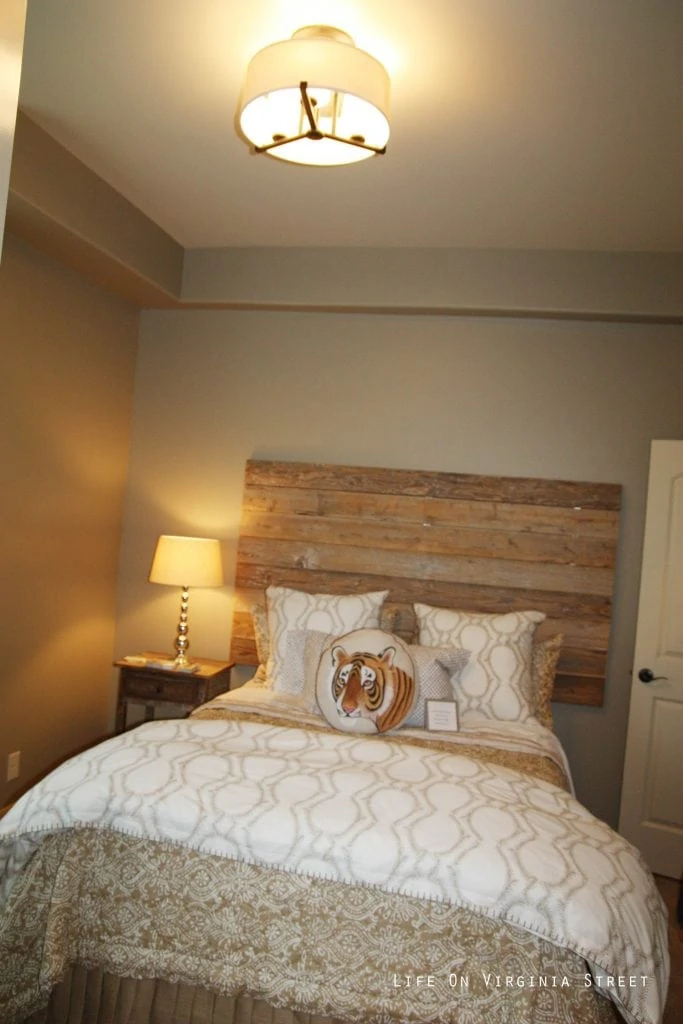 Neutral bedroom with wood pallet headboard, white trellis bedding and tiger throw pillow.