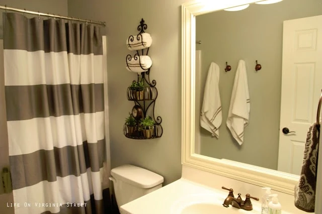 A striped brown and white shower curtain is hanging in the guest bathroom.