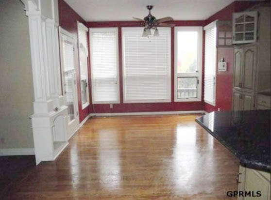 A large window with red walls in the dining room.