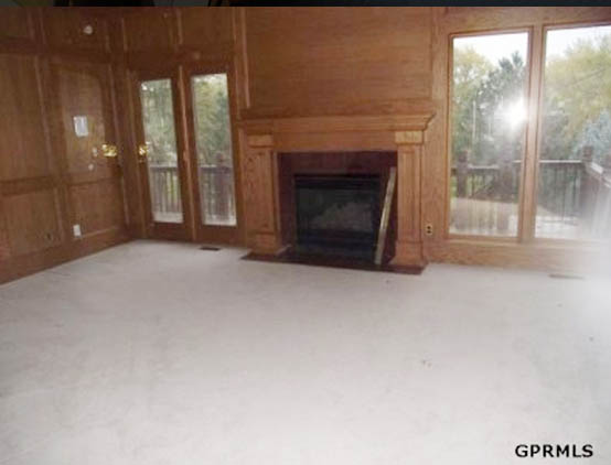 A wood panelled room with a fireplace in the middle of the room.