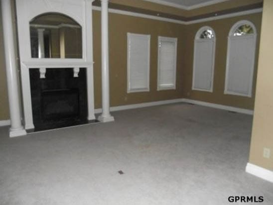 An olive painted room with a white fireplace and white mouldings.
