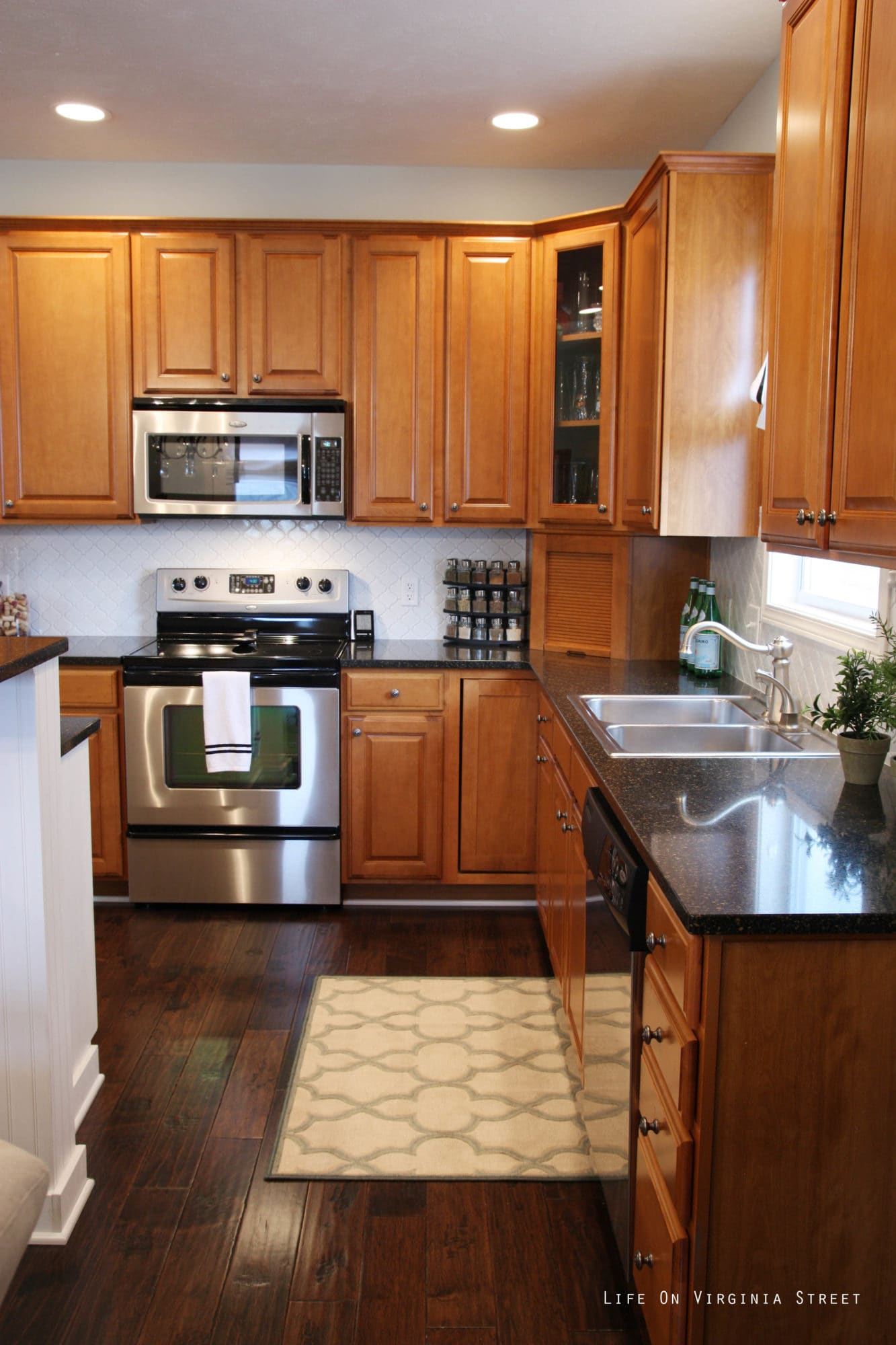 A wood kitchen with black countertops.