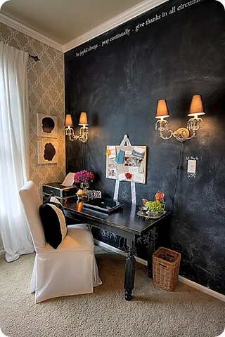 Full chalkboard wall in office with wall sconces on it.