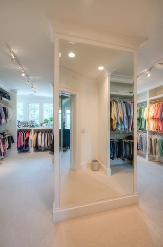 Walk-in closet with windows and full-length mirror.