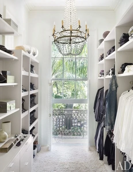White closet with chandelier and windows.