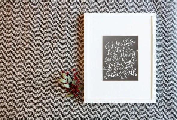 O Holy Night Print hanging on the textured wall.