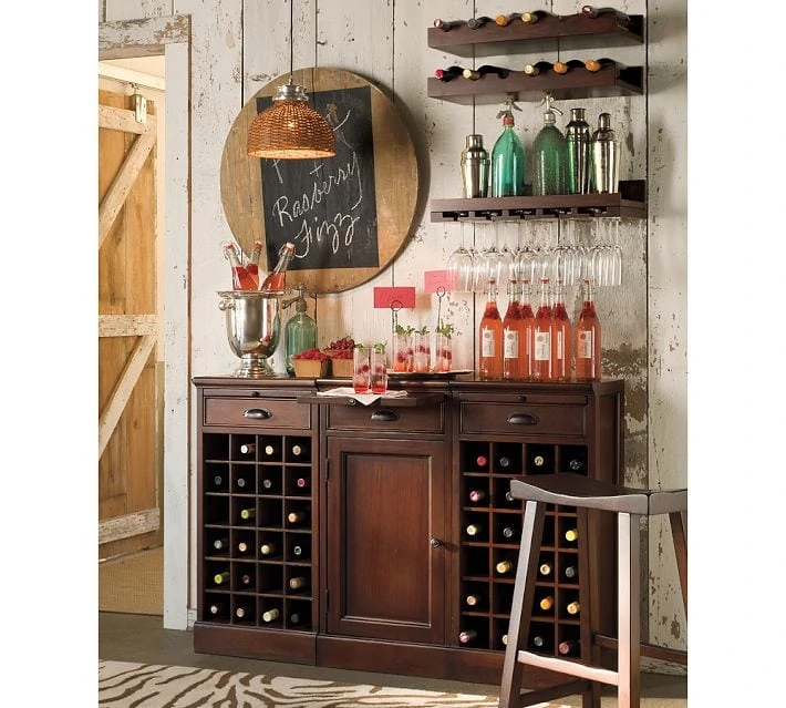 Dark wooden hutch holding wine bottles, glasses and tumblers.