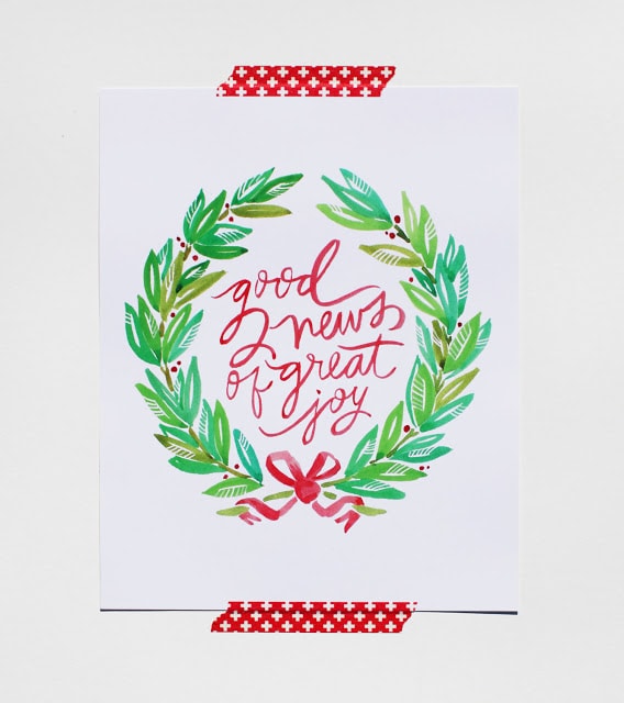 Good news of great joy print with a green wreath around it taped to wall.