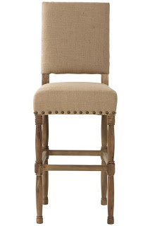 A linen stool and large rivets on the bottom of the seat and wooden legs.