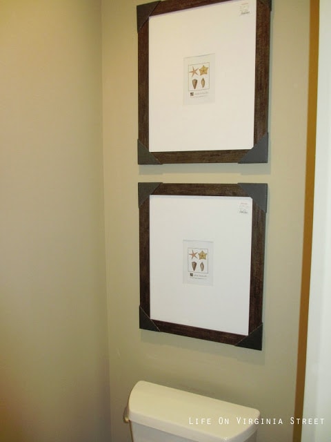 Large pictures beside the toilet in the bathroom.