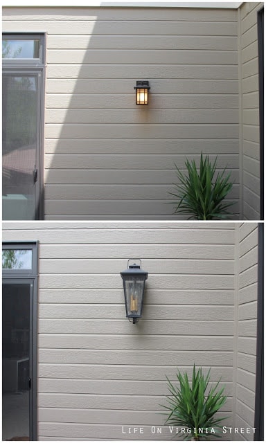 A small square light and a larger lantern light on the side of the house.