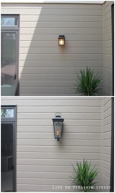 A small square light and a larger lantern light on the side of the house.