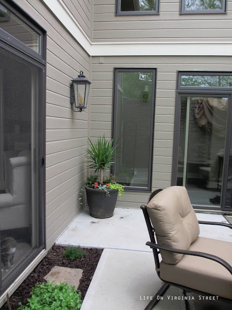 A metal brown chair with light brown cushions on the patio.